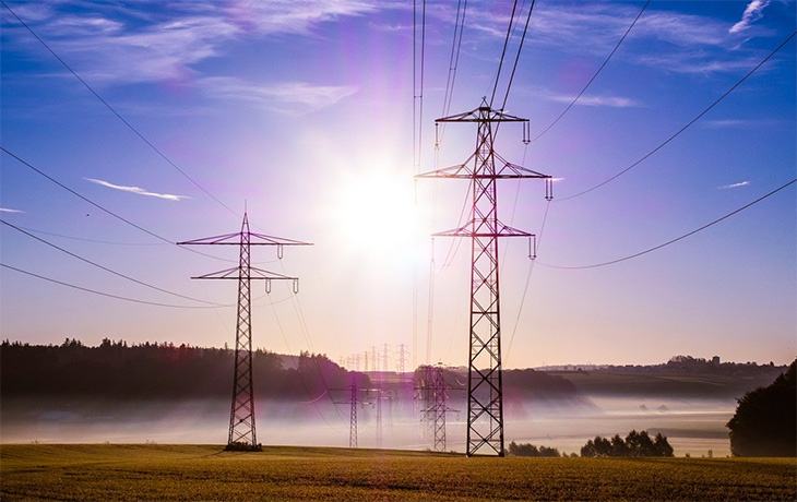 Electricity pylons in front of a sunset